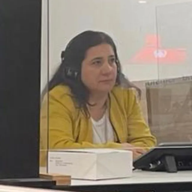 Saiga Abbasova mit Kopfhörer in einer Dolmetschkabine